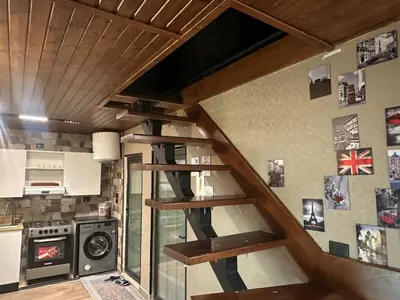 a wooden staircase in a kitchen with a stove at Umm Aljulud Cottages 01 in Ajloun