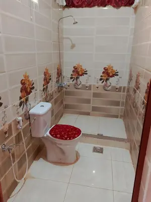 a bathroom with a toilet with a red seat at Wadi Rum Sands Story Camp &Tours in Wadi Rum