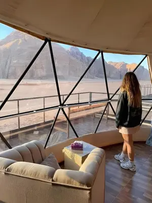 a woman standing in a room looking out at the desert at Wadi rum tenda camp in Wadi Rum