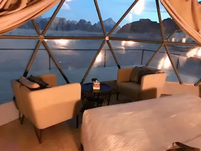a room with two beds and a table in a boat at Wadi rum lona camp in Wadi Rum