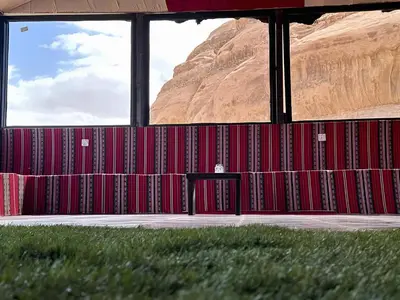 a room with red walls with a mountain in the background at Wadi rum lona camp in Wadi Rum