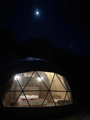 a view of a dome at night with a moon at Wadi rum lona camp in Wadi Rum