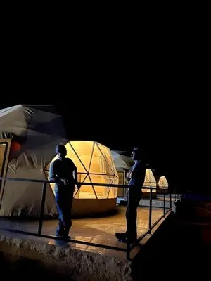 two men standing on a stage next to a tent at Wadi rum lona camp in Wadi Rum