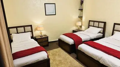a hotel room with two beds and two lamps at Petra center suite in Wadi Musa