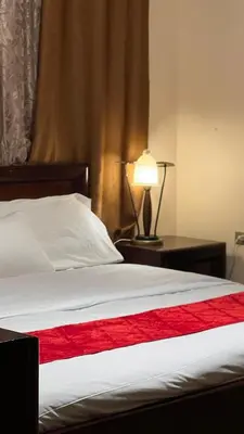 a bedroom with a bed with a red blanket and a lamp at Petra center suite in Wadi Musa
