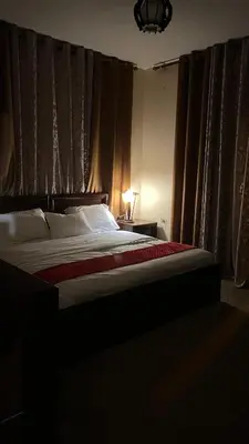 a bedroom with a large bed with a red blanket at Petra center suite in Wadi Musa
