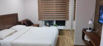a bedroom with a large white bed and a window at Fully furnished studio in Amman