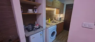a small kitchen with a washing machine and a washer at Fully furnished studio in Amman