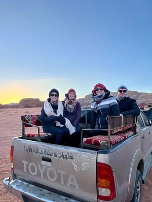 a group of people sitting in the back of a truck at Wadi rum naef camp in Wadi Rum