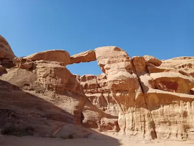 an arch in the rocks in the desert at Wadi rum naef camp in Wadi Rum