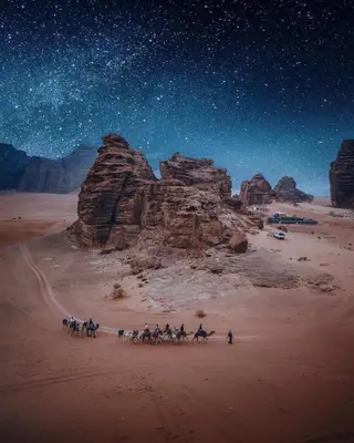 a group of people riding horses in the desert at night at ROYAL SAVOY lUXURY CAMP in Wadi Rum