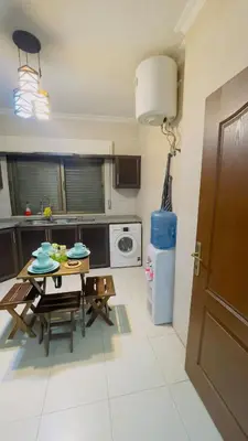 a kitchen with a table and a dining room at شقة مفروشة في طبربور in Amman