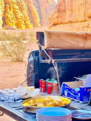 a grill with plates of food on a table at Seven Pillars Luxury Camp in Wadi Rum