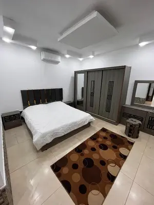 a bedroom with a large bed and a rug at Al Zain Chalet - Private Pool in Al Kafrayn