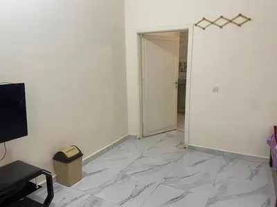 an empty room with a white wall and a door at هوستل خدمه مبيت in Disah