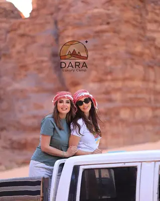 two women standing in the back of a truck at DARA RUM lUXURY CAMP in Wadi Rum