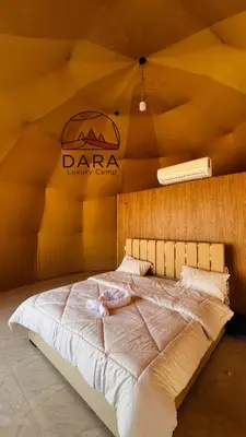 a woman laying on a bed in a tent at DARA RUM lUXURY CAMP in Wadi Rum