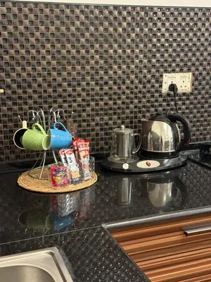 a kitchen counter with a sink and a tea kettle at Abdallah Wa'el Adham in Aqaba