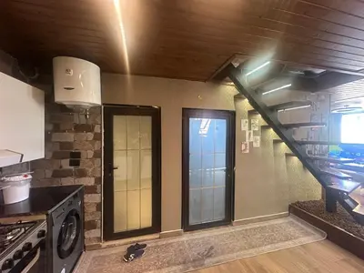 a kitchen with a staircase and a stair case at Umm Aljulud Cottages 02 in Ajloun