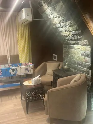 a living room with two chairs and a couch at Umm Aljulud Cottages 02 in Ajloun