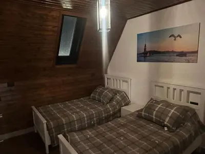 a bedroom with two beds and a window and a picture at Umm Aljulud Cottages 02 in Ajloun