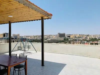 a table and chairs on a roof with a view at City View Rooftop Apartment Amman in Amman