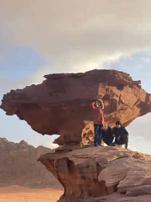 three people standing on a rock in the desert at Rum Desert Silence Camp in Wadi Rum