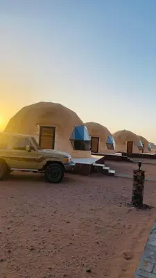 a truck parked in front of a row of domes at Rum Desert Silence Camp in Wadi Rum