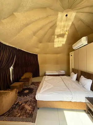 a bedroom with a bed in a room with a ceiling at NAJMA lUXURY CAMP in Wadi Rum