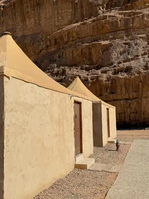 a building with a tent in front of a canyon at NAJMA lUXURY CAMP in Wadi Rum
