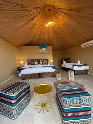a hotel room with three beds and a ceiling at Giulia Rum Luxury Camp in Wadi Rum