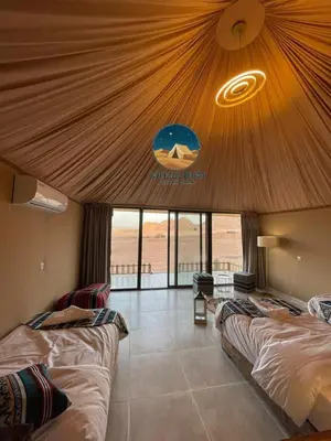 two beds in a room with a large ceiling at Giulia Rum Luxury Camp in Wadi Rum