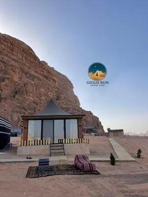 a building in the middle of a desert with a mountain at Giulia Rum Luxury Camp in Wadi Rum