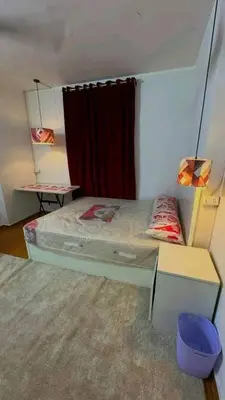 a small bedroom with a bed and a red curtain at Vrtn hotel in Amman