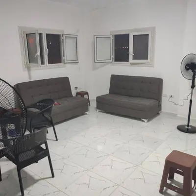 a living room with couches and chairs and windows at Abu yousef chalet in Irbid