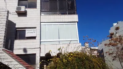 a tall white building with a window on it at Abdoun rose in Amman