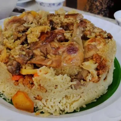 a plate of food with rice and meat and vegetables at Petra House for Traditional Jordanian Food in Petra