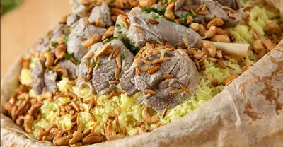 a plate of food with meat and nuts on it at Petra House for Traditional Jordanian Food in Petra