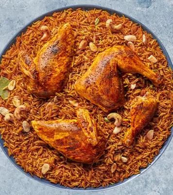 a plate of food with chicken and rice and nuts at Petra House for Traditional Jordanian Food in Petra