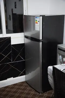 a stainless steel refrigerator in a kitchen with black at Petra Bed Hostel in Petra
