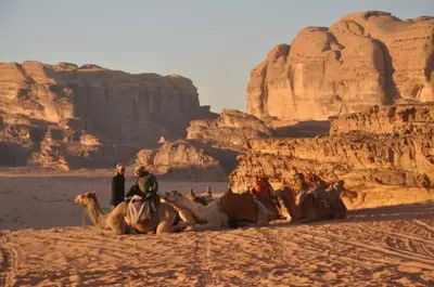 a group of people riding on camels in the desert at Rum Adventure Camp in Wadi Rum