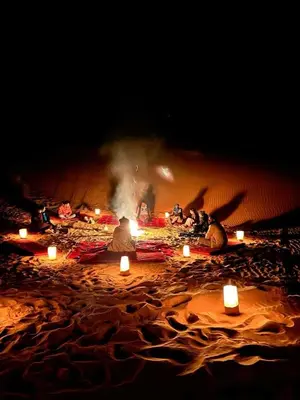 a group of people sitting on a beach with candles at Silent Sands Lodge in Disah