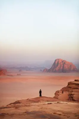a man standing on a rock in the desert at Silent Sands Lodge in Disah