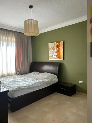 a bedroom with a bed in a green wall at Luxury Apartment for Daily Rent in Shmaisani in Amman