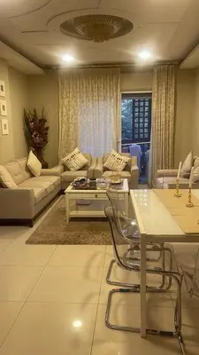a living room with a couch and a table at Al qaoud apartment in Aydūn