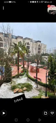 a view of a park with trees and a building at Al qaoud apartment in Aydūn