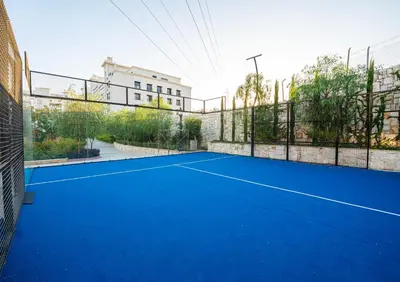 a blue tennis court with a fence at كمباوند شقة مفروشة كومباوند الامعري المطار in Amman