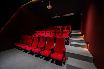 an auditorium with red chairs in a theatre at كمباوند شقة مفروشة كومباوند الامعري المطار in Amman