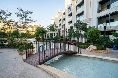 a bridge over a pool of water in a city at كمباوند شقة مفروشة كومباوند الامعري المطار in Amman