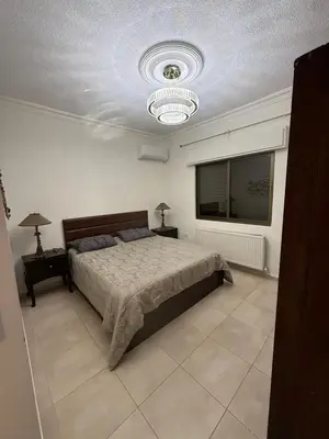 a bedroom with a bed and a ceiling at Furnished luxuries Apartment with a Stunning View in Amman